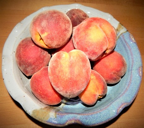 Bowl with whole raw peaches